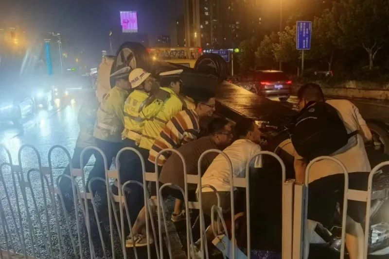 現(xiàn)場交警和路過的群眾一起將車輛抬起翻轉(zhuǎn)長沙晚報通訊員供圖圖片